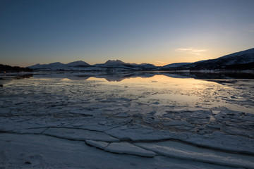 A Norwegian fjord near Troms&oslash; covered with ice at sunset, Troms&oslash;, Norway