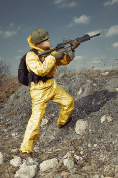 Freak gunman afraid of atomic war in yellow overall pointing noticeably on target