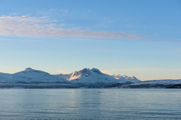 Fototapeta na wymiar Bright landscapes taken from the waters of the Fjords around Tromsø, Norway