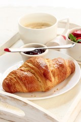 Breakfast in Bed with Croissant Jam strawberries and Coffee in tray, selective focus