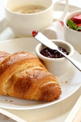 Breakfast in Bed with Croissant Jam strawberries and Coffee in tray, selective focus