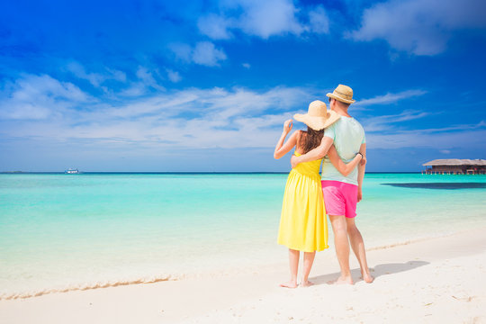 happy young couple walking by the beach