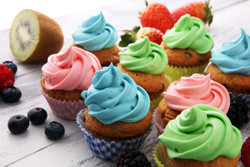 Obraz na płótnie Canvas Tasty cupcakes on wooden background. Birthday cupcake in rainbow colors
