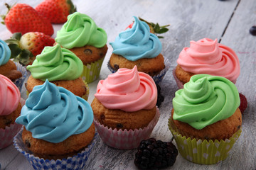 Tasty cupcakes on wooden background. Birthday cupcake in rainbow colors