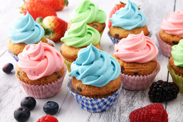 Tasty cupcakes on wooden background. Birthday cupcake in rainbow colors