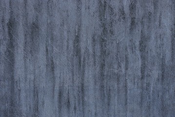 The dark gray stone texture of a dirty concrete wall