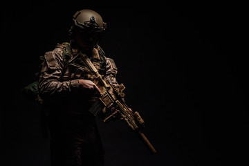 Special forces United States soldier or private military contractor holding rifle. Image on a black...