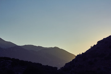Beautiful sunset, blue sky and dark silhouette of mountains on the island of Crete, Greece