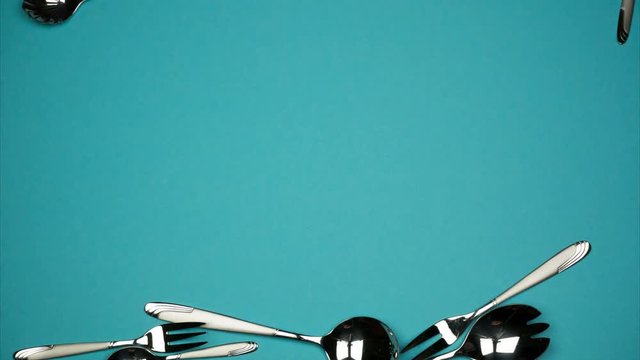 Falling spoons and forks on the blue background. 