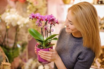 Girl holding a beautiful pink orchid in pot
