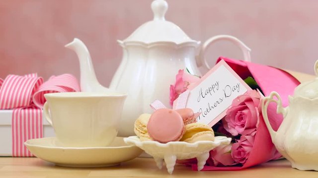 Mother's Day tea setting with teapot, macaron cookies, pink roses and gift.
