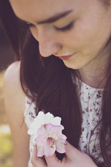 Girl holds blooms in her hand and looking at them