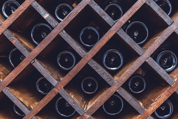 бутылки вина лежат в деревянной винотеке в винном погребе 