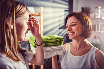 Mother and daughter talking and laughing at laundry room