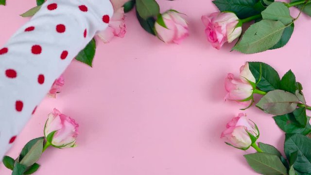 Time lapse of Mother's Day overhead background of pink roses and macaron cookies on pink wood table.