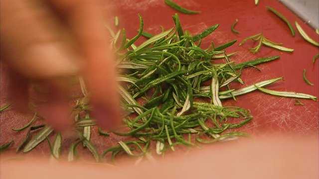 A medium shot of a person chopping garlic