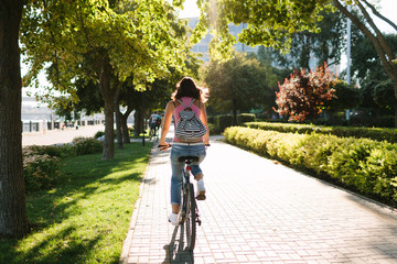 Fototapeta premium girl with a backpack cycling around the city