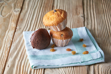 Chocolate and vanilla muffins with nuts on wooden background, selective focus