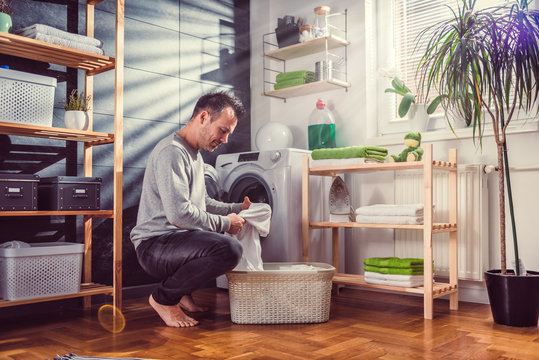 Man putting clothes into washing machine