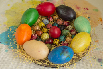 Theme Easter. Multicolored eggs of quail, hen and duck on straw.