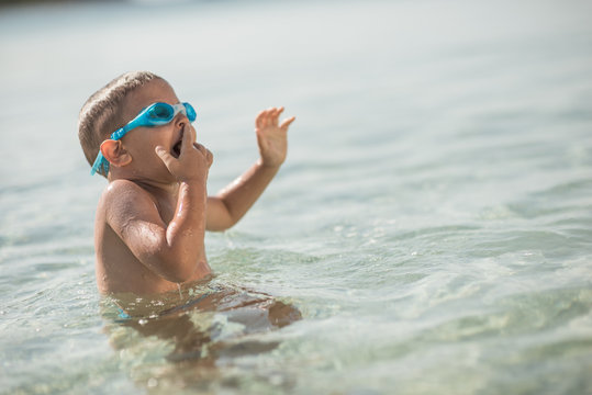 Little boy sittning in water with diving mask