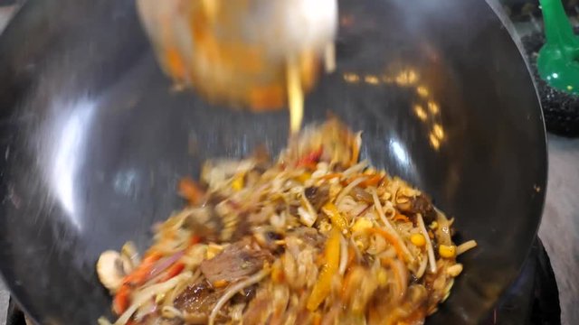Slow motion (60fps) - Stir fry asian noodles and vegetables dish in the making.