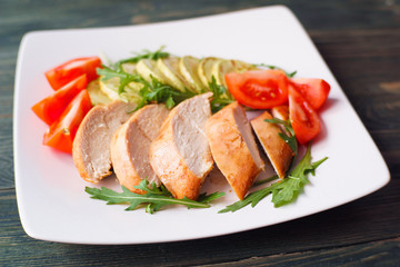 Diet food, proteins, healthy low-calorie meals concept. Baked chicken breasts with zucchini, tomatoes and arugula, close up