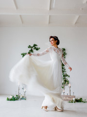 Young bride raises her wedding dress