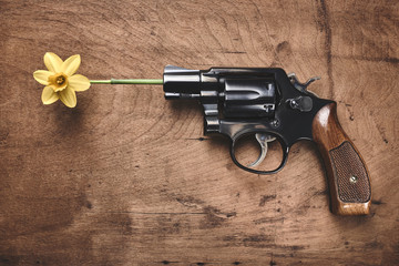 concept shot of a gun with a flower 