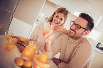 Couple drinking orange juice at home