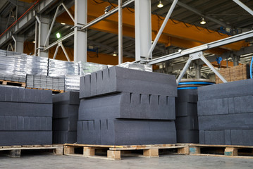 Paving slabs factory. Tiles piled in pallets. Warehouse paving slabs in the factory for its...