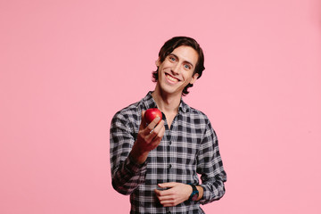 young man in checkered shirt offering an apple 
