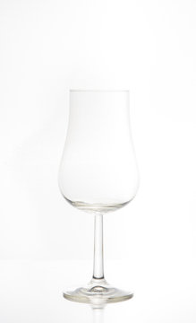 Ett tomt vinglas i silhuett som väntar på att flyllas av ett smakrikt rött vin