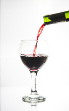 Vi fyller ett ovalt vinglas belyst i siluett med ett r&ouml;tt vin f&ouml;r att vi ska se hur vinet flyter