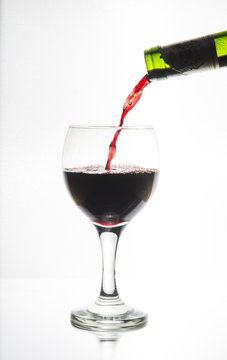 Vi fyller ett ovalt vinglas belyst i siluett med ett r&ouml;tt vin f&ouml;r att vi ska se hur vinet flyter