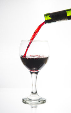 Vi fyller ett ovalt vinglas belyst i siluett med ett r&ouml;tt vin f&ouml;r att vi ska se hur vinet flyter