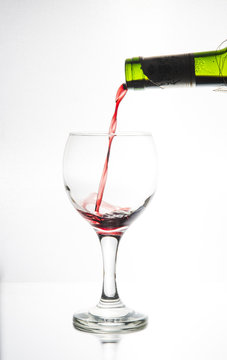 Vi fyller ett ovalt vinglas belyst i siluett med ett r&ouml;tt vin f&ouml;r att vi ska se hur vinet flyter