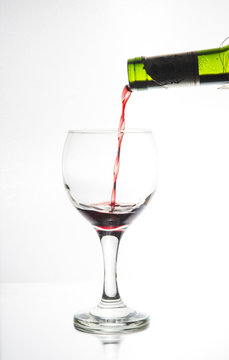 Vi fyller ett ovalt vinglas belyst i siluett med ett r&ouml;tt vin f&ouml;r att vi ska se hur vinet flyter