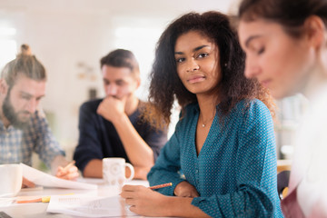 Portrait of a young black woman looking in a work meeting