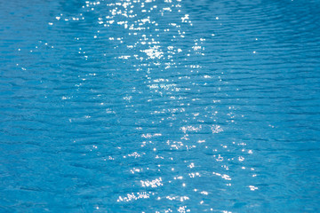 water ripples texture in swimming pool with sunny glare