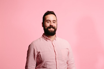 Casual young Man with beard and a big smile  isolated on pink background