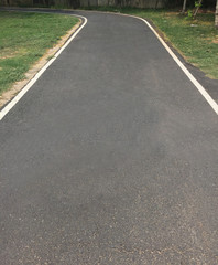 Black asphalt winding Road transport going to the distance with white line at public park
