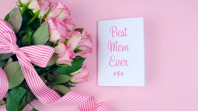 Happy Mother's Day overhead with roses, Best Mom Ever card and gift on pink wood table.