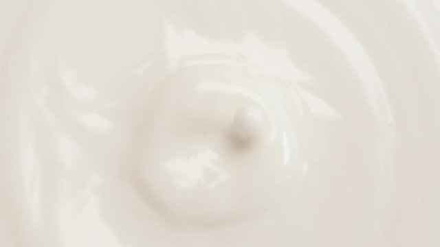 Beauty milk drop into cream. Macro shot of milk dropping in super slow motion