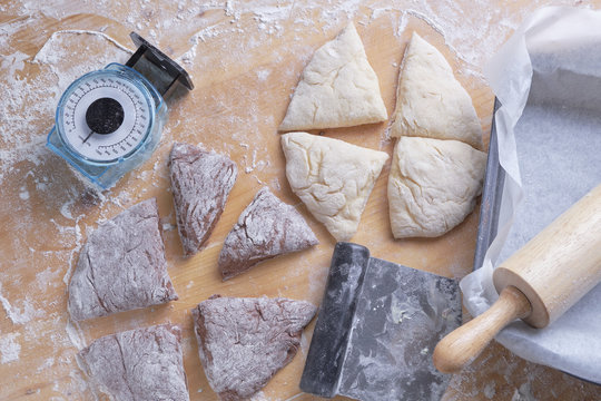 High angle view of dough by baking sheet and rolling pin on wooden table