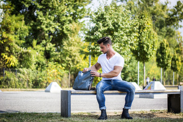 Obraz premium Attractive muscular man in city park in a nice summer day