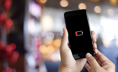 Close up man hands using smart phone battery low charged battery screen