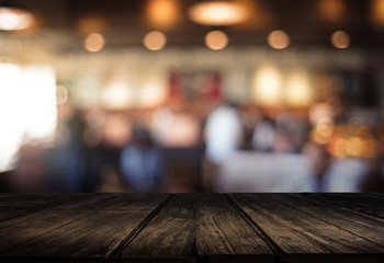 Fototapeta premium Wooden board empty table cafe, coffee shop, bar blurred background can be used for display or montage your products and Mock up