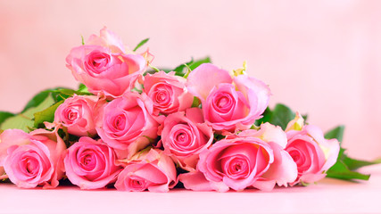 Pink roses on pink wood table, Happy Mother's Day background closeup with copy space.