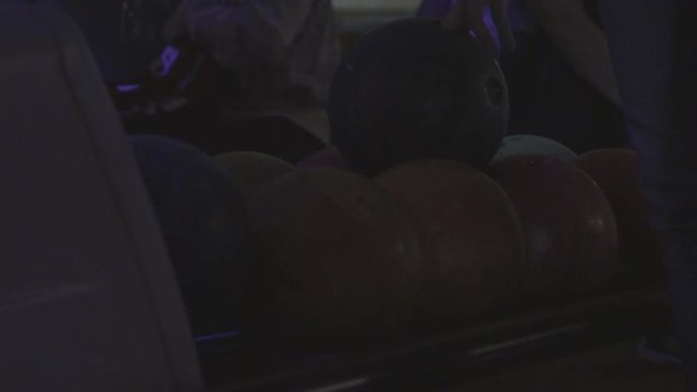 Picking up a bowling ball from a rack 